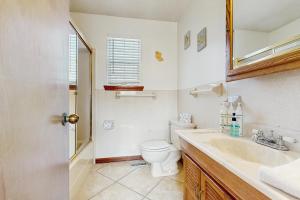 a white bathroom with a toilet and a sink at Seascape in Folly Beach +18 photos