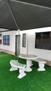 a table and two benches sitting on green grass at VM Guesthouse Premium Suites in Estcourt