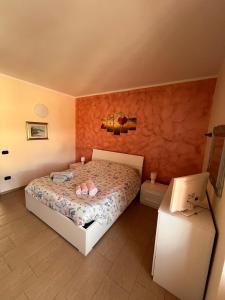 a bedroom with a bed with pink shoes on it at Casa Vacanze DEFUK in Montefiascone
