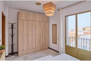 a bedroom with a large wooden cabinet and a window at CASA FILO VISTAS MONTAÑa in Rute