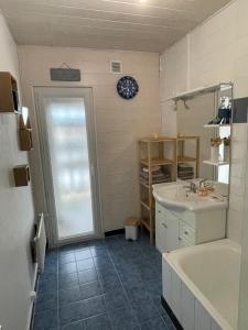 a bathroom with a tub and a sink and a bath tub at Appartement cosy et calme au cœur de Landerneau in Landerneau