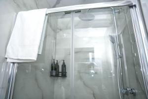 a shower with a glass door and a towel at Spacious 4-Bed Home with Free Parking in Heston +53 photos
