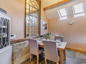 a dining room with a wooden table and chairs at The Cow Shed - farm cottage close to Stratford in Temple Grafton +5 photos