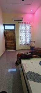 a room with a bed and a door with a window at Angel hill resort in Chonp