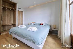 een slaapkamer met een bed met handdoeken erop bij Le Schlossreben - La Maison des Vignerons in Orschwiller