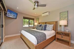 a bedroom with a bed and a ceiling fan at Hale Nui · HALE NUI Luxury Retreat 5BD w Private Pool Hot Tub in Kaanapali +40 photos
