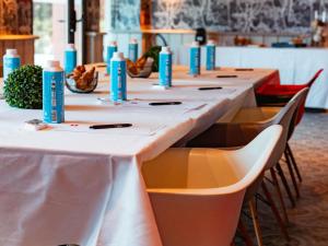 a row of long tables with chairs in a room at ibis Marseille Provence Aéroport in Marignane +122 photos