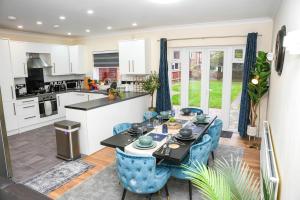 a kitchen and living room with a table and chairs at Spacious 4-Bed Home with Free Parking in Heston
