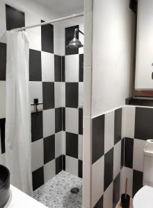 een badkamer met een zwart-wit geblokte muur bij Gite Le Soupadou in Albas