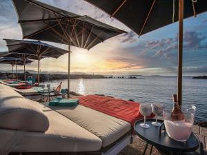 a bed with two tables with umbrellas on the water at Pullman Cannes Mandelieu in Mandelieu-La Napoule