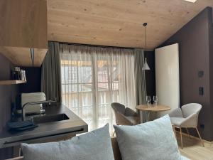 a kitchen with a sink and a table with chairs at La Maison 35 - Bruneck - zentral gelegene Appartments in Brunico