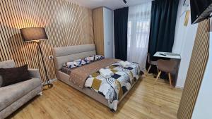 a bedroom with a bed and a couch and a desk at Next to Coco's Apartment in Tirana
