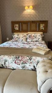 a bedroom with a large bed with flowers on it at Casa Ohana - Miguel Pereira in Miguel Pereira