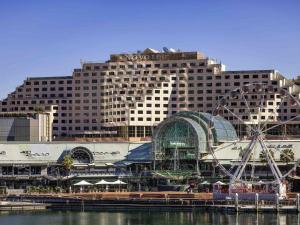 een groot hotel met een achtbaan voor het water bij Novotel Sydney Darling Harbour in Sydney