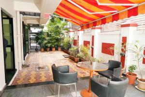 a lobby with a table and chairs and plants at Hotel Suraj Classic in Pune