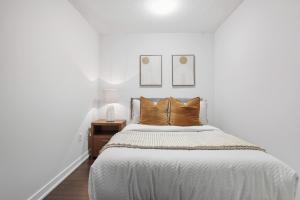 ein weißes Schlafzimmer mit einem großen Bett und braunen Kissen in der Unterkunft Trendy 1BR Condo Free Parking Downtown Toronto in Toronto
