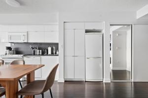 eine Küche mit Holztisch und Kühlschrank in der Unterkunft Trendy 1BR Condo Free Parking Downtown Toronto in Toronto