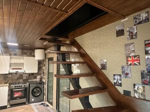 a wooden staircase in a kitchen with a stove at Umm Aljulud Cottages 02 in Ajloun