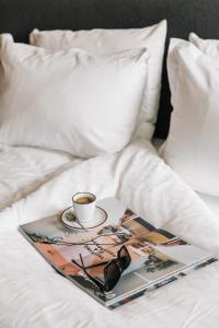 a tray with a cup of coffee and glasses on a bed at The Social Hub Eindhoven in Eindhoven