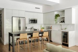 a kitchen with white cabinets and a black table and chairs at ROOST White House in Washington, D.C.
