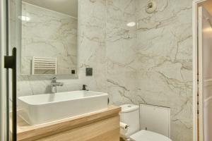 a white bathroom with a sink and a toilet at Le Duplex - Disneyland - Rooftop - Wifi in Montévrain +54 photos