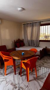 a living room with a table and chairs and a bed at Résidence Ndackel in Kammba