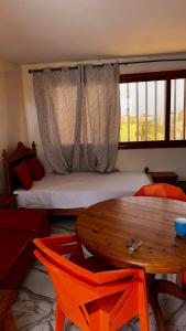 a bedroom with a bed and a table and a table and chairs at Résidence Ndackel in Kammba