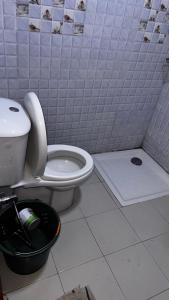 a bathroom with a toilet and a trash can at Résidence Ndackel in Kammba