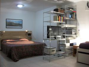 a bedroom with a bed and a book shelf at Appartamento - terrazzo vivibile vista mare, wi-fi e box gratuiti in Vallecrosia