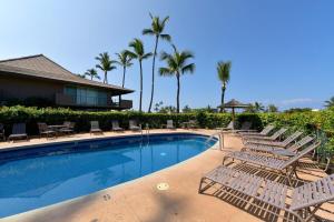 a resort swimming pool with lounge chairs and palm trees at Eldorado L202 · EL L202 Updated Condo with Beachfront Cabana in Kahana