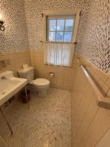 a bathroom with a toilet and a sink and a window at Historic Wayne Street - close to the Stadium in South Bend +22 photos