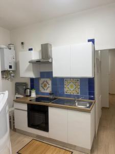 a kitchen with white cabinets and a sink at Casa La Perla in Montevarchi