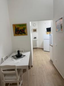 a kitchen with a white table and a white refrigerator at Casa La Perla in Montevarchi