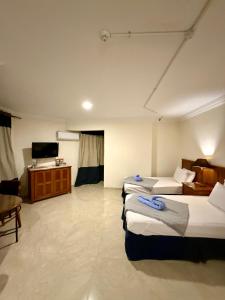 a hotel room with three beds and a television at Bianchi Hotel in Alexandria +107 photos