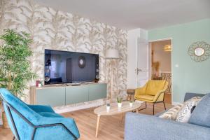 a living room with a couch and a tv at Le Duplex - Disneyland - Rooftop - Wifi in Montévrain