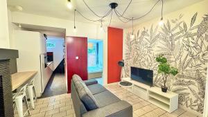 a living room with a couch and a tv at 2 chambres en RDC avec terrasse 4 personnes in Douai