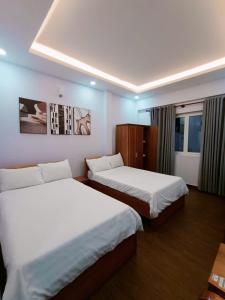 a hotel room with two beds and a window at 102 House in Ho Chi Minh City