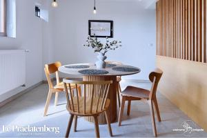 een eettafel met stoelen en een vaas erop bij Le Praelatenberg - La Maison des Vignerons in Orschwiller