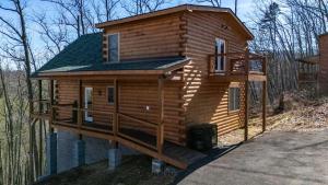 a cabin in the woods with a wrap around porch at Luxury Cabin with Hot Tub and Resort Access in Sevierville +47 photos