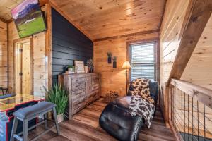 a living room with a leather chair in a cabin at Luxury Cabin with Hot Tub and Resort Access in Sevierville
