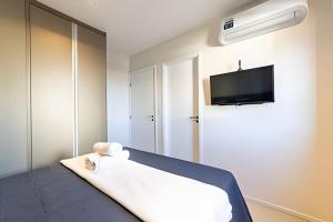 a room with a bed and a flat screen tv at Edifício Mosaico do Mar - Seu Refugio na Praia da Jatiúca in Maceió +21 photos