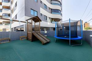 a playground with a slide and a swing at Edifício Mosaico do Mar - Seu Refugio na Praia da Jatiúca in Maceió