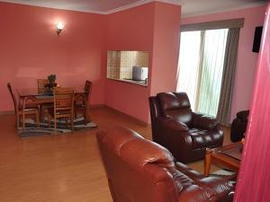 a living room with a couch and a table and chairs at YOD Abyssinia International Hotel and Cultural Restaurant in Addis Ababa