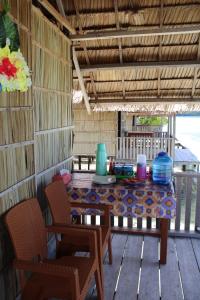 una mesa y sillas en un porche con mesa y sillas en Maricho Homestay, en Besir