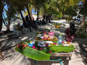 a picnic table on the beach with people sitting at Fehivilla resistance in Dhangethi