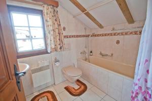 a bathroom with a toilet and a tub and a sink at Furggen, Chalet Museum in Grächen +10 photos