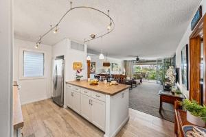 a kitchen with white cabinets and a dining room at Eldorado E204 · EL E204 Lanai with View Pool AC Beach Cabana Gym in Kaanapali