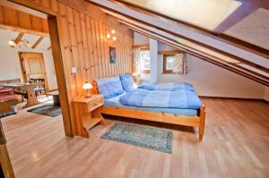 a bedroom with a bed with blue sheets in it at Furggen, Chalet Museum in Grächen