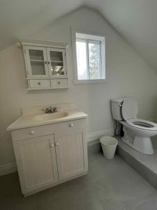 a white bathroom with a toilet and a sink at Chalet lac Chantelle in Chertsey +33 photos