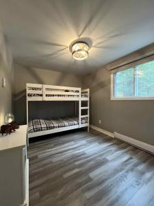 a bedroom with two bunk beds and a ceiling fan at Chalet lac Chantelle in Chertsey